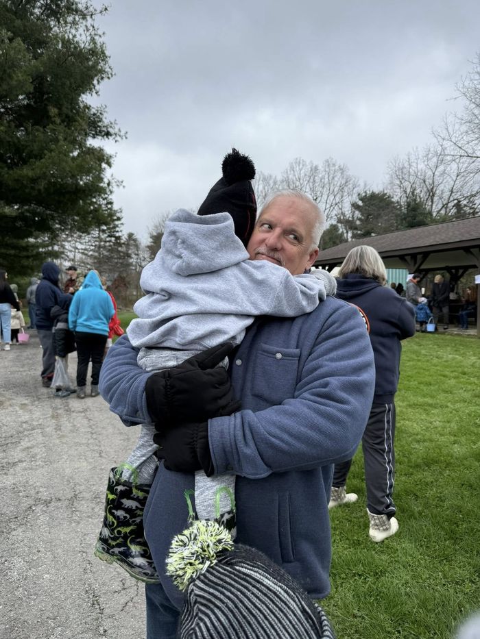 Michael Hovis hugging a grandchild at an outdoor community event
