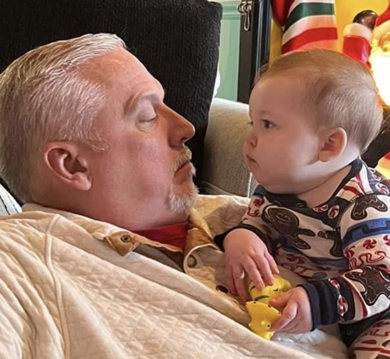Michael Hovis resting with a grandbaby on his chest