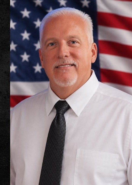 Michael J. Hovis in front of the American flag